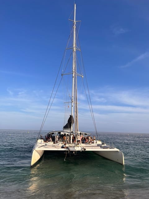 Lloret de Mar: Sunset Catamaran Cruise with DJ and Drinks - The swim stop in a tranquil inlet
